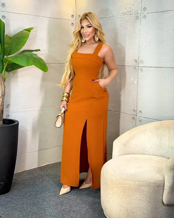 Modelo com vestido longo laranja, foto de uma das peças da loja de demonstração